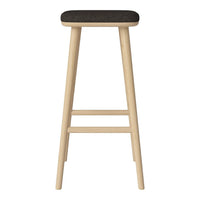 "Light wood bar stool with a dark fabric seat, featuring a minimalist design and clean lines."