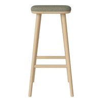 Wooden bar stool with natural finish and a textured olive green fabric seat. Simple and modern design.