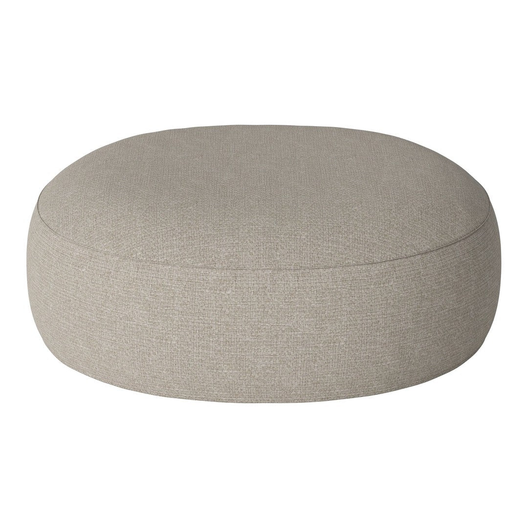 Round ottoman in light beige fabric with a smooth, textured finish, perfect for adding style to any room.