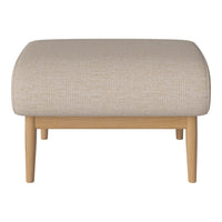 Beige textured ottoman with a rounded top and light wood legs, perfect for modern decor.