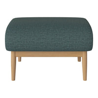 Teal patterned ottoman with natural wood legs, perfect for stylish and modern home decor.
