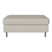 Light beige ottoman with a smooth texture and subtle fabric pattern, featuring sleek silver legs.