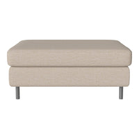 Beige upholstered ottoman with a smooth, textured surface and sleek metal legs.