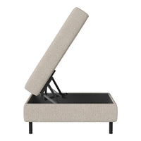 Light beige upholstered storage ottoman with a black base, featuring a simple, modern design.