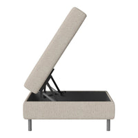 Beige upholstered storage ottoman with a textured finish and sleek black base, showcasing modern design.