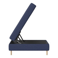 Navy blue upholstered lift-top storage ottoman with a subtle textured pattern and natural wood legs.