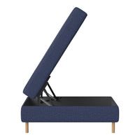 Navy blue upholstered storage bed with a textured pattern and light wood legs, partially lifted for storage access.