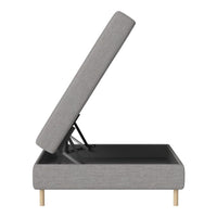 Gray upholstered storage bed with a sleek design and natural wood legs, showcasing a minimalist modern aesthetic.