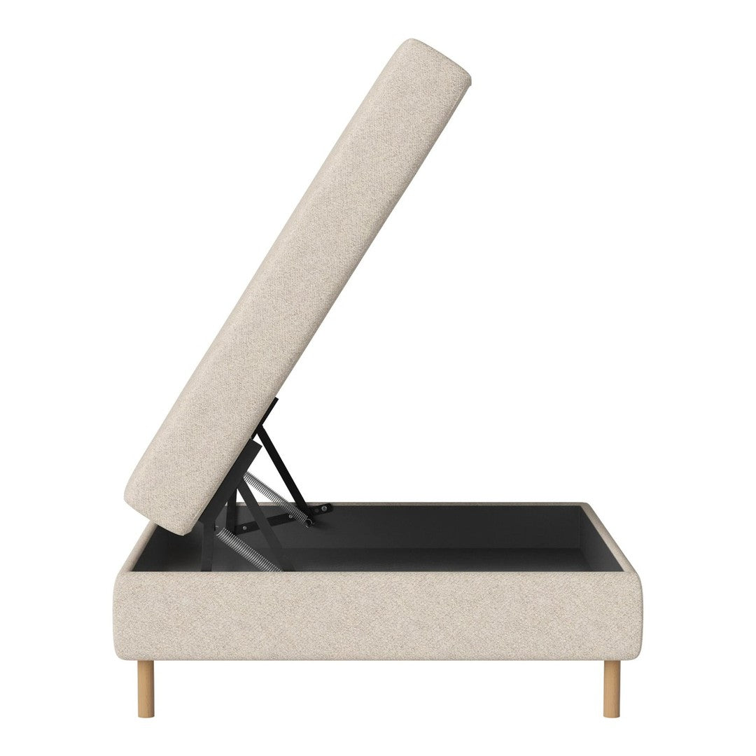 Beige upholstered lift-top storage ottoman with light wood legs and a smooth, minimalist design.