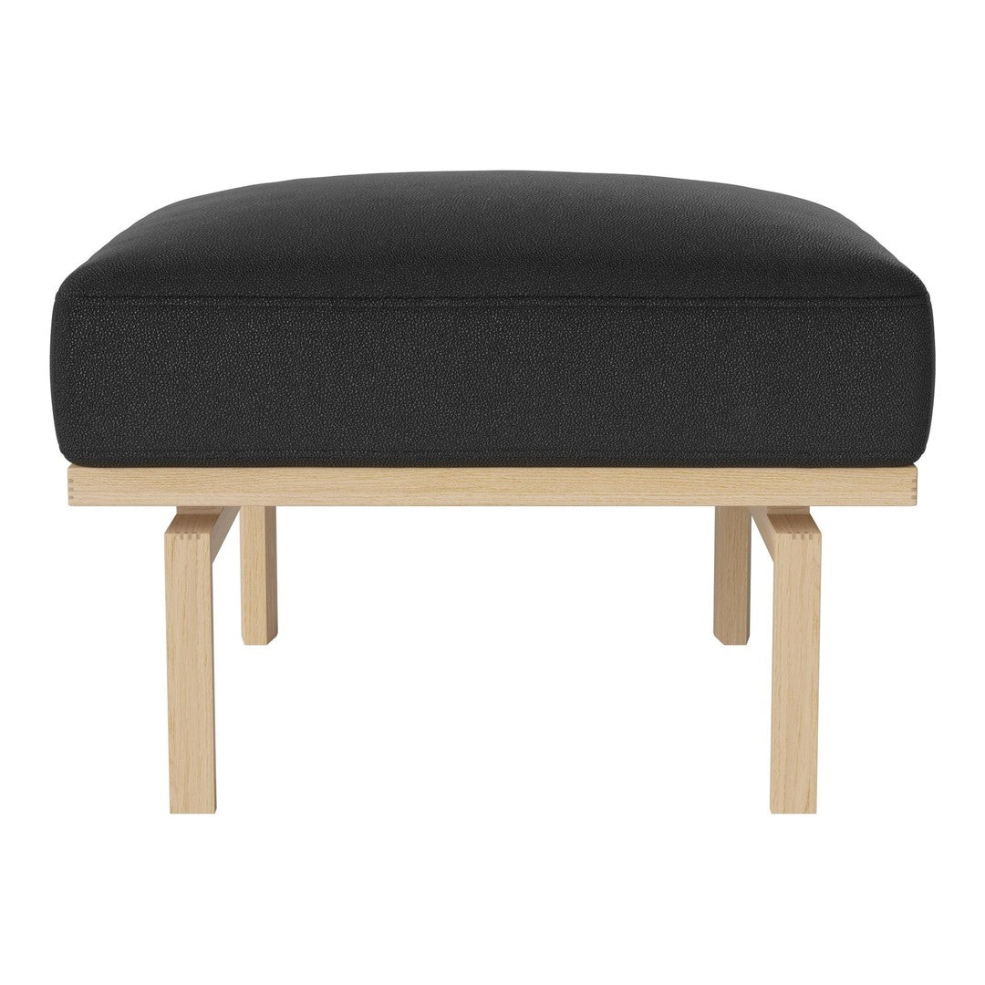 Black upholstered ottoman with a simple, modern wooden base. Minimalist design for contemporary decor.