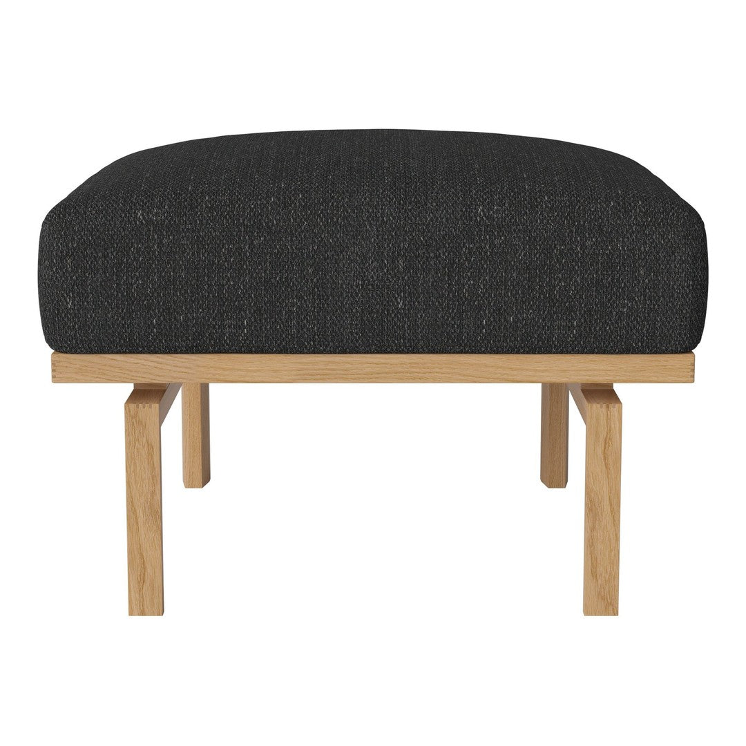 Black upholstered ottoman with a textured finish and natural wood legs. Minimalist design for modern interiors.