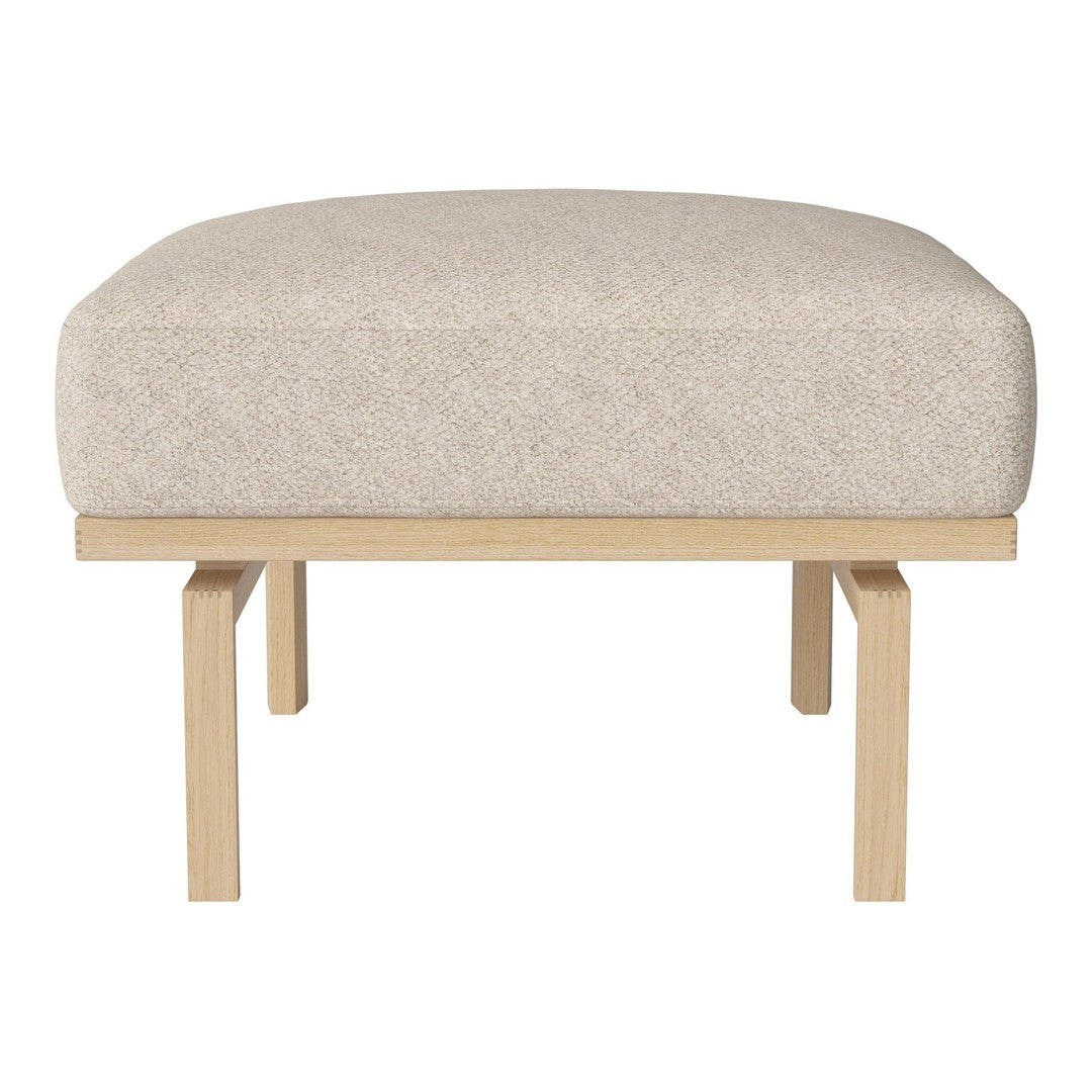 Light beige upholstered ottoman with a smooth, textured surface and natural wood legs, showcasing a minimalist design.