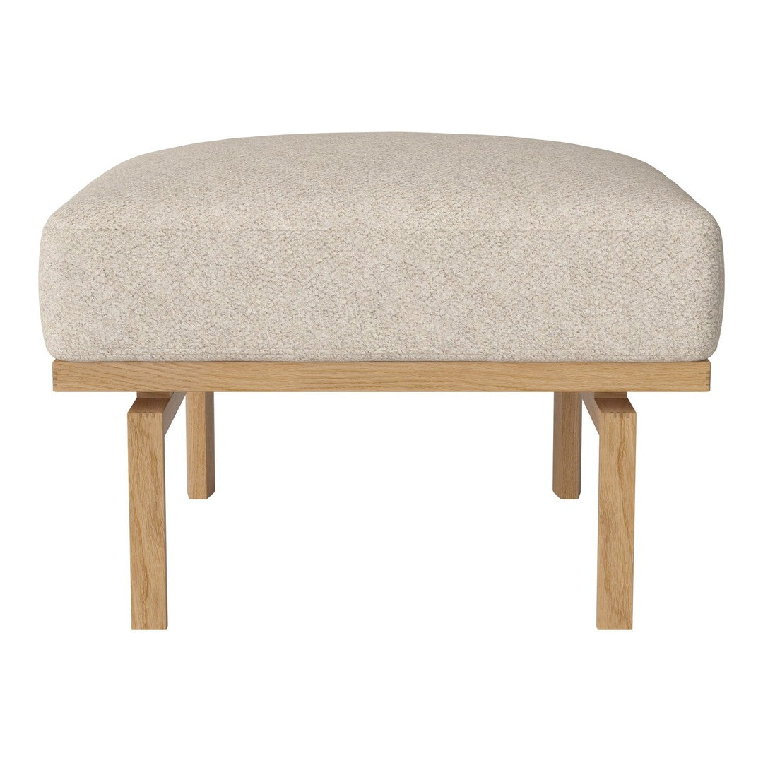 Neutral beige upholstered ottoman with clean lines and natural wood legs, ideal for modern decor.