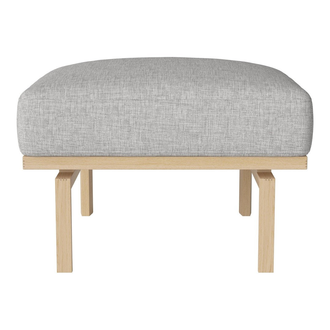 Gray upholstered ottoman with a smooth texture on a light wood frame. Ideal for modern decor.