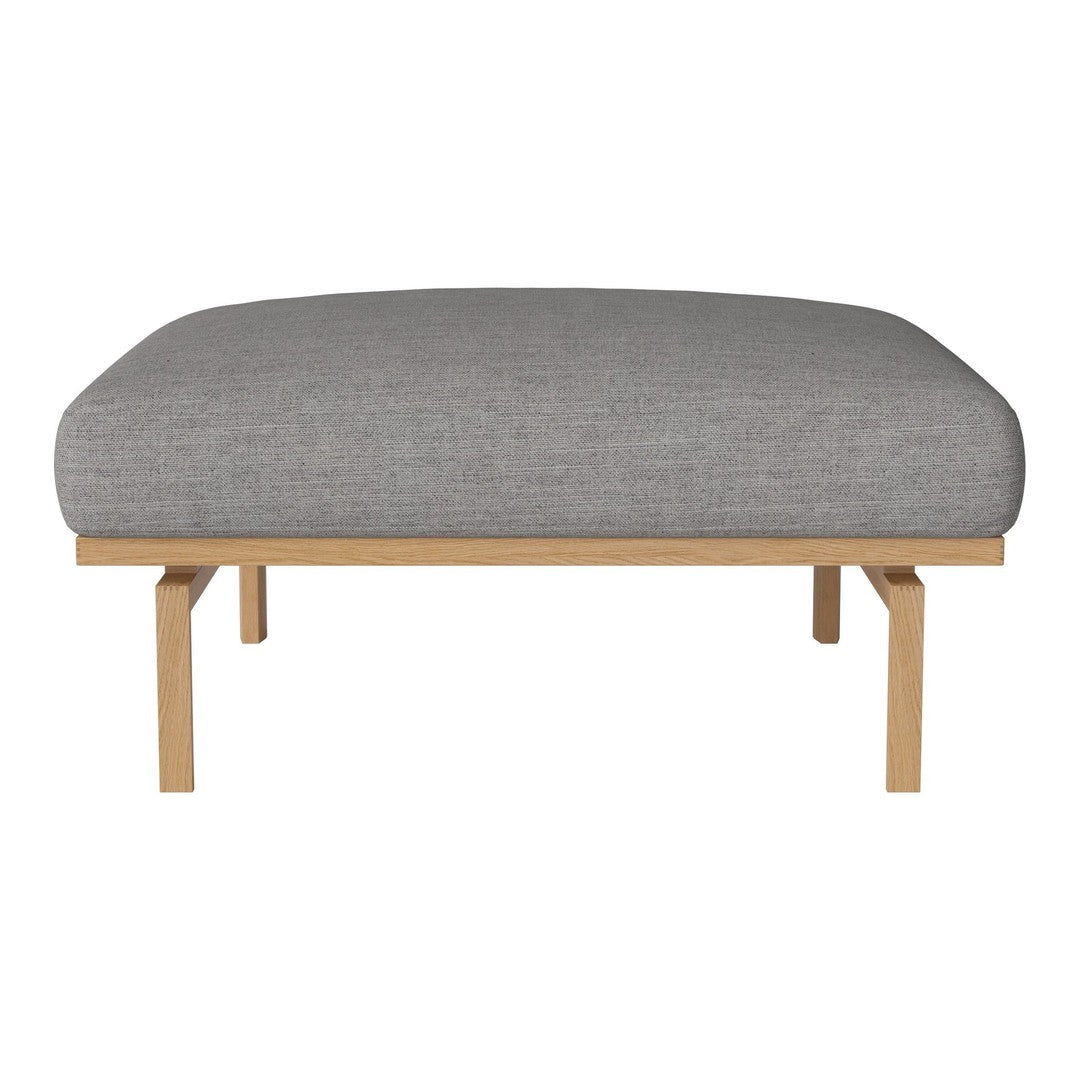 Gray cushioned ottoman with a smooth texture and natural wood frame, perfect for stylish living spaces.