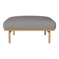 Gray cushioned ottoman with a smooth texture and natural wood frame, perfect for stylish living spaces.
