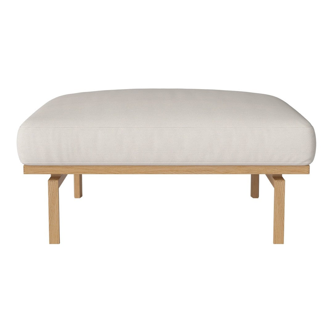 Cream-colored padded seat with a minimalist design and light wooden legs. Smooth texture, modern style.