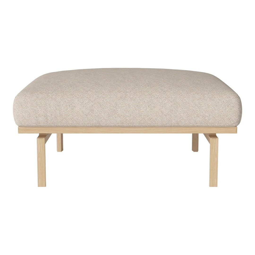 Beige upholstered ottoman with a smooth texture atop light wood legs, ideal for modern décor.
