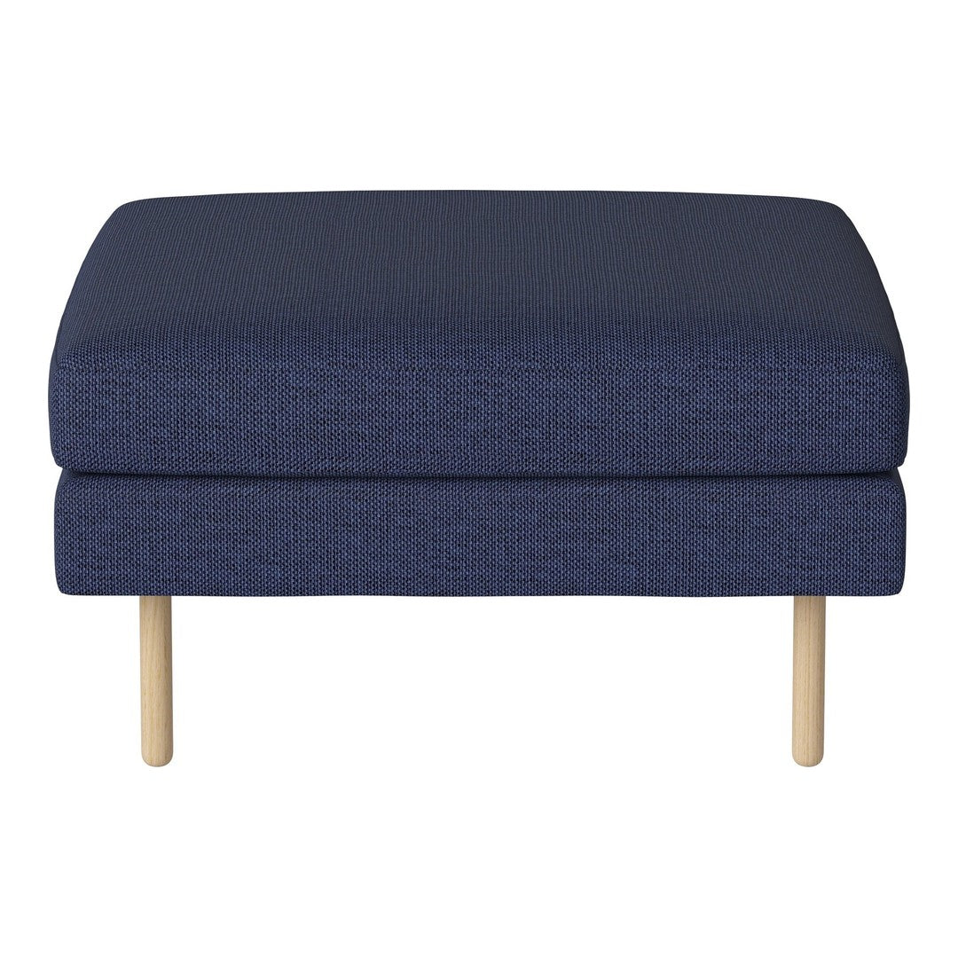Navy blue upholstered ottoman with a textured pattern and light wood legs. Ideal for modern decor.