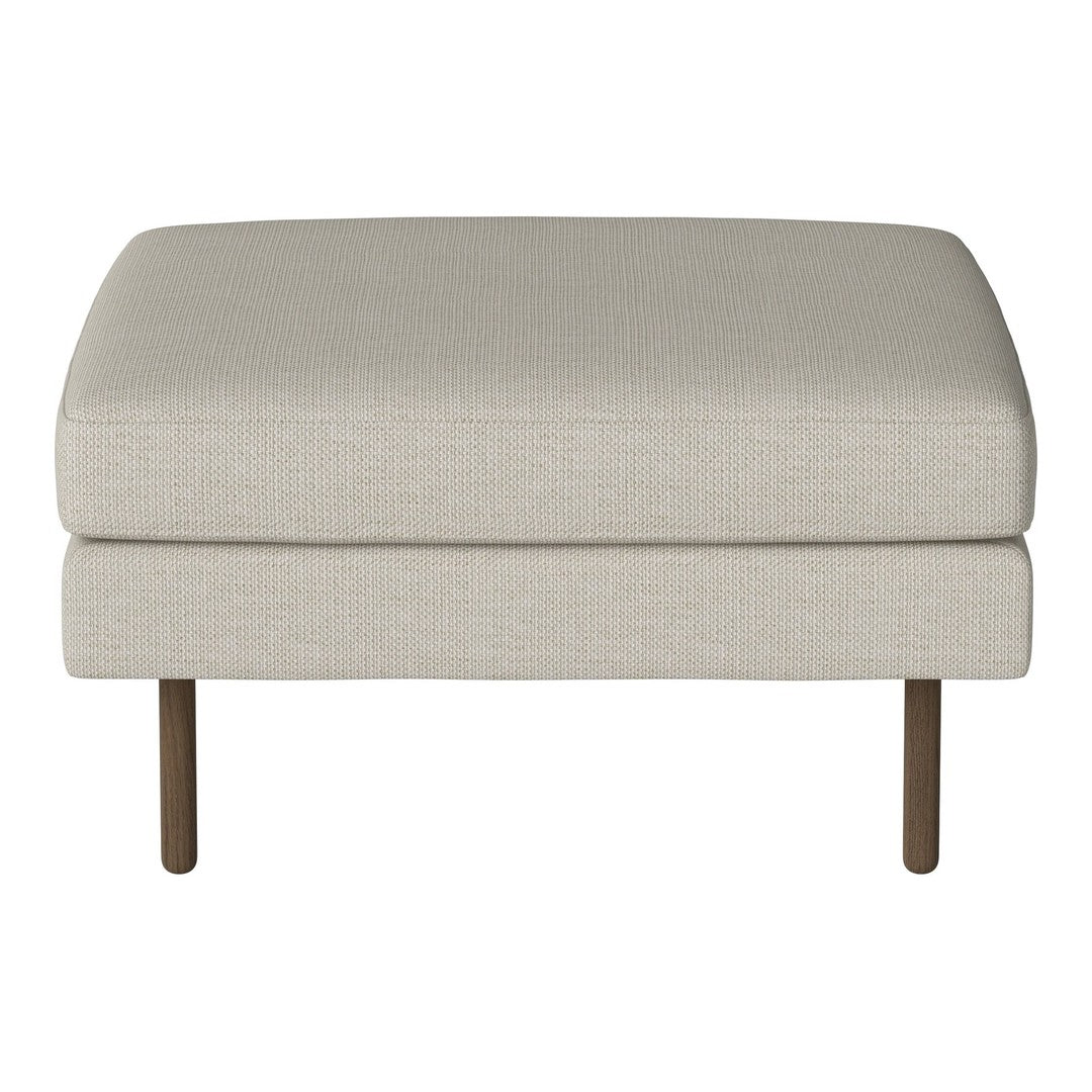Beige upholstered ottoman with a smooth, textured surface and minimalist design, supported by slender brown legs.
