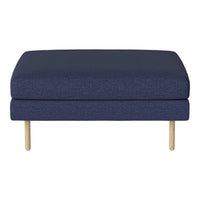 Navy-blue upholstered ottoman with a textured fabric and natural wooden legs. Modern, minimalist design.