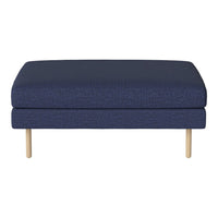 Navy blue ottoman with a textured fabric surface and light wooden legs, perfect for modern decor.