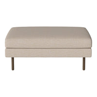 Beige upholstered ottoman with a smooth texture and sleek metal legs, perfect for modern decor.