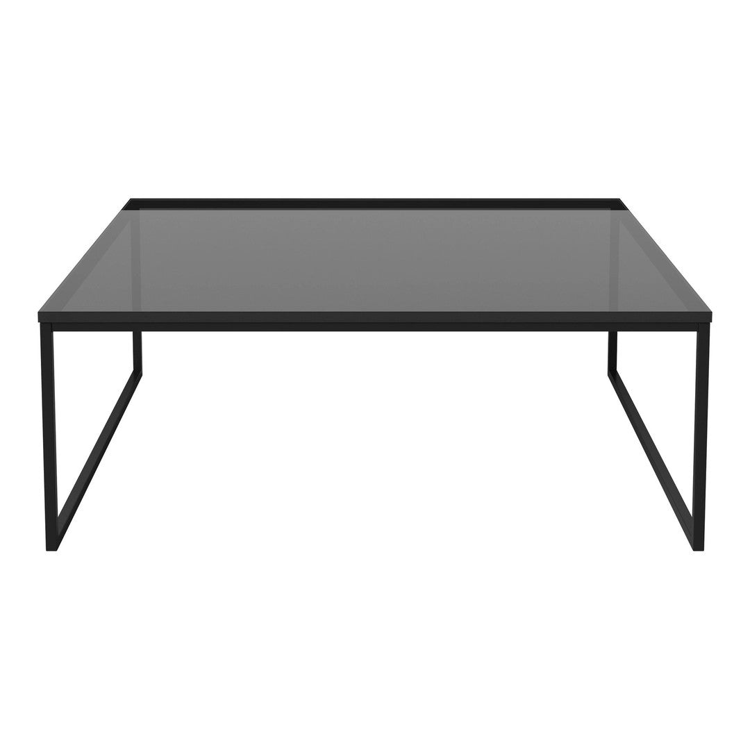 Sleek black coffee table with a smooth glass top and minimalist design, perfect for modern interiors.