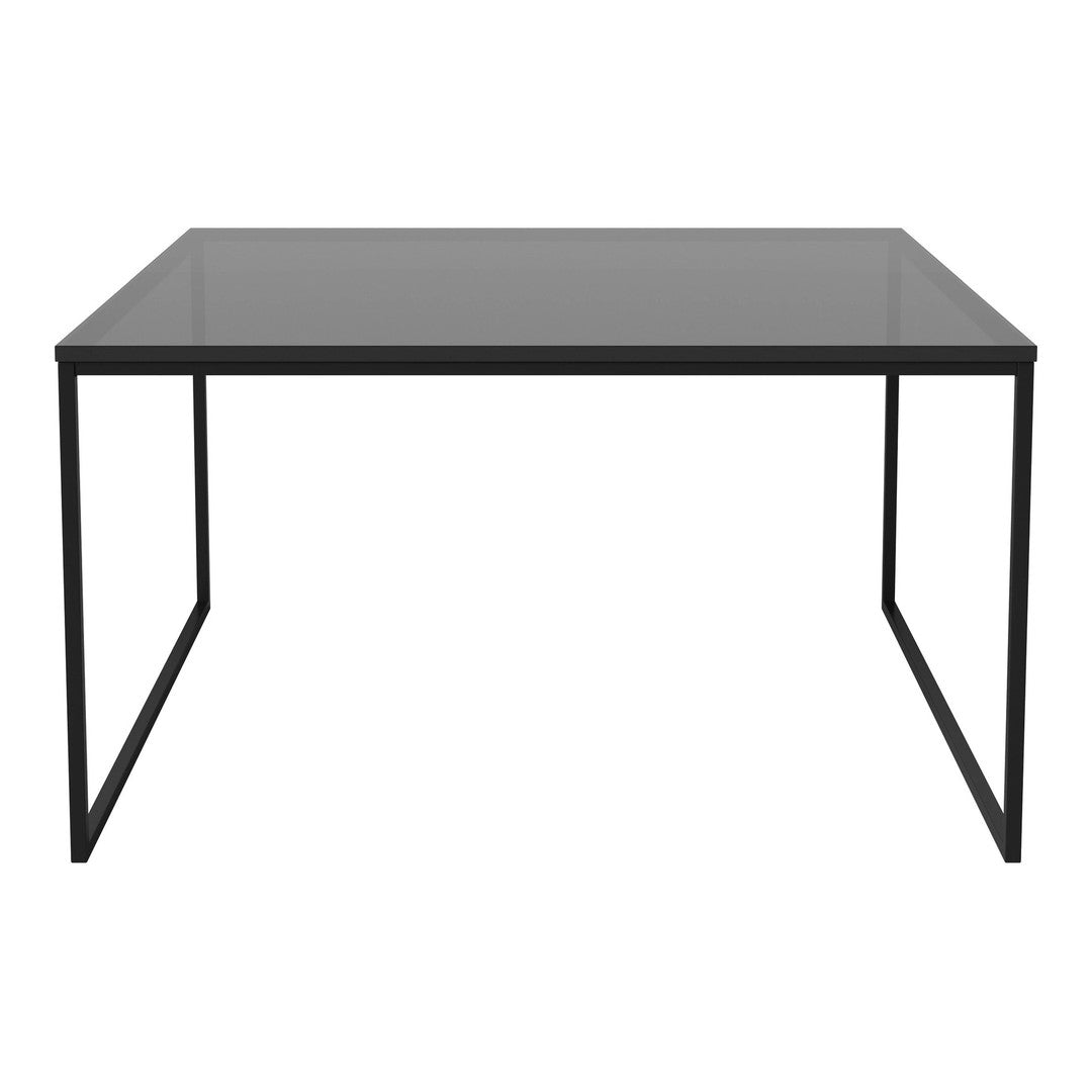 Modern black metal table with sleek glass top, featuring a minimalist design and smooth, reflective surface.