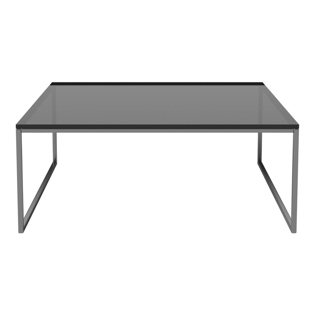 Rectangular glass coffee table with a sleek black metal frame and smooth grey top, perfect for modern decor.