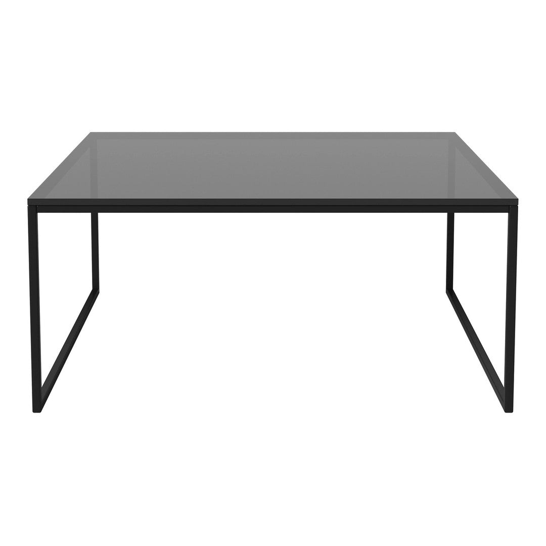 Modern black metal frame coffee table with a sleek, dark glass top. Minimalist design complements any decor style.