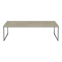Rectangular coffee table with a smooth gray top and sleek metal legs, showcasing a minimalist, modern design.