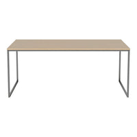 Minimalist beige desk with sleek gray metal legs, perfect for modern workspace styling.