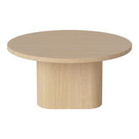 Round light wood coffee table with a smooth surface and minimalist design, featuring a cylindrical base.