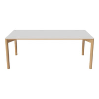 Rectangular dining table with a sleek white top and natural wood legs, perfect for modern and minimalist decor.