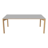 Modern rectangular dining table with a sleek grey top and natural wood legs, perfect for contemporary spaces.