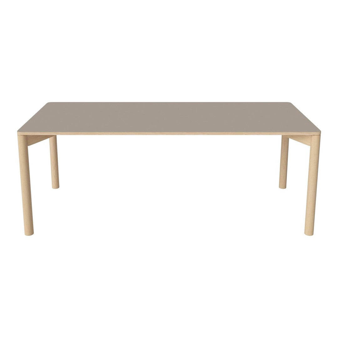 Rectangular dining table in soft beige with a smooth surface and minimalistic design, featuring light-colored legs.