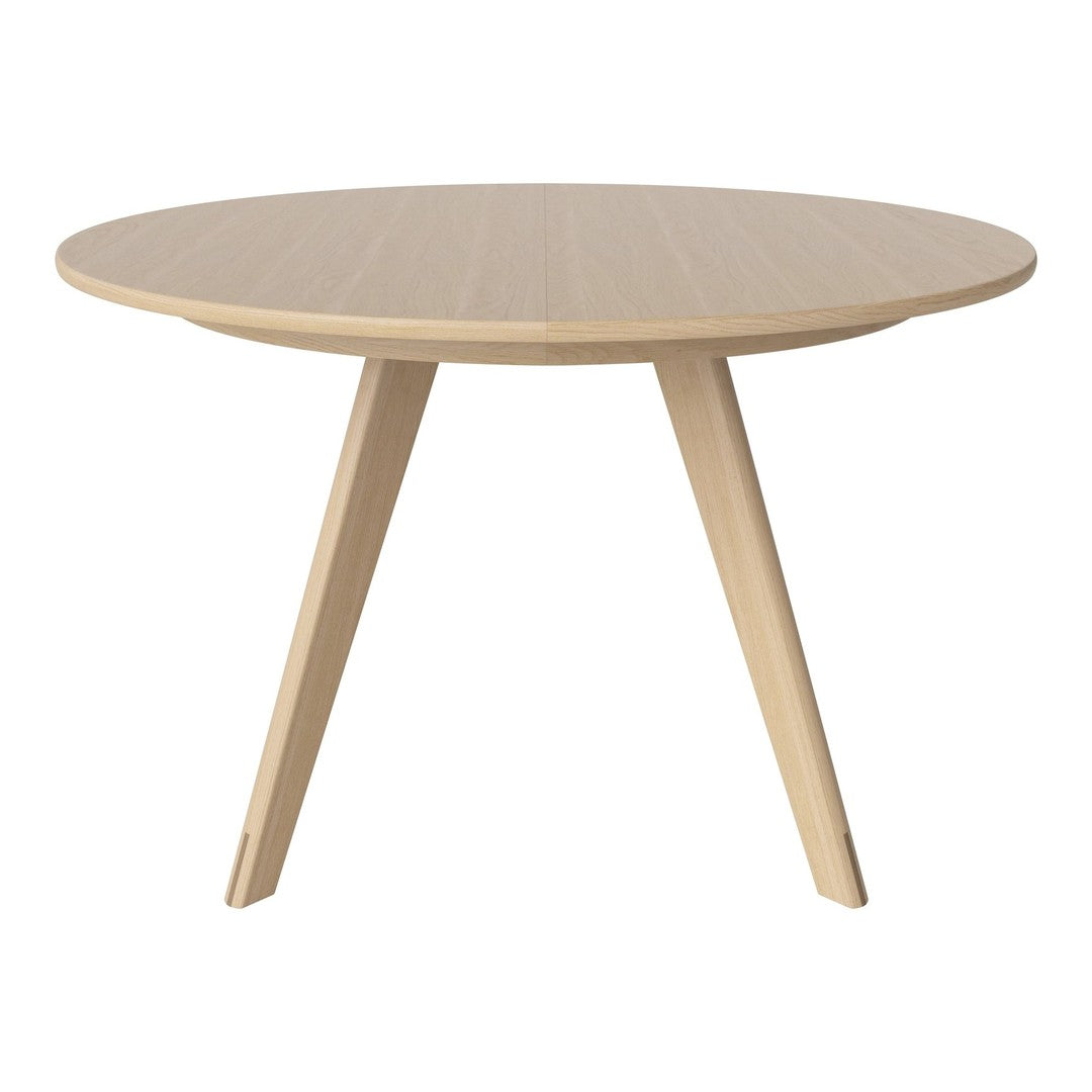 Round wooden table with a light beige finish and subtle, natural wood grain pattern. Elegant, modern design.