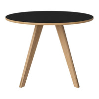 Round table featuring a sleek black top with natural wood legs in a light finish, highlighting a modern aesthetic.