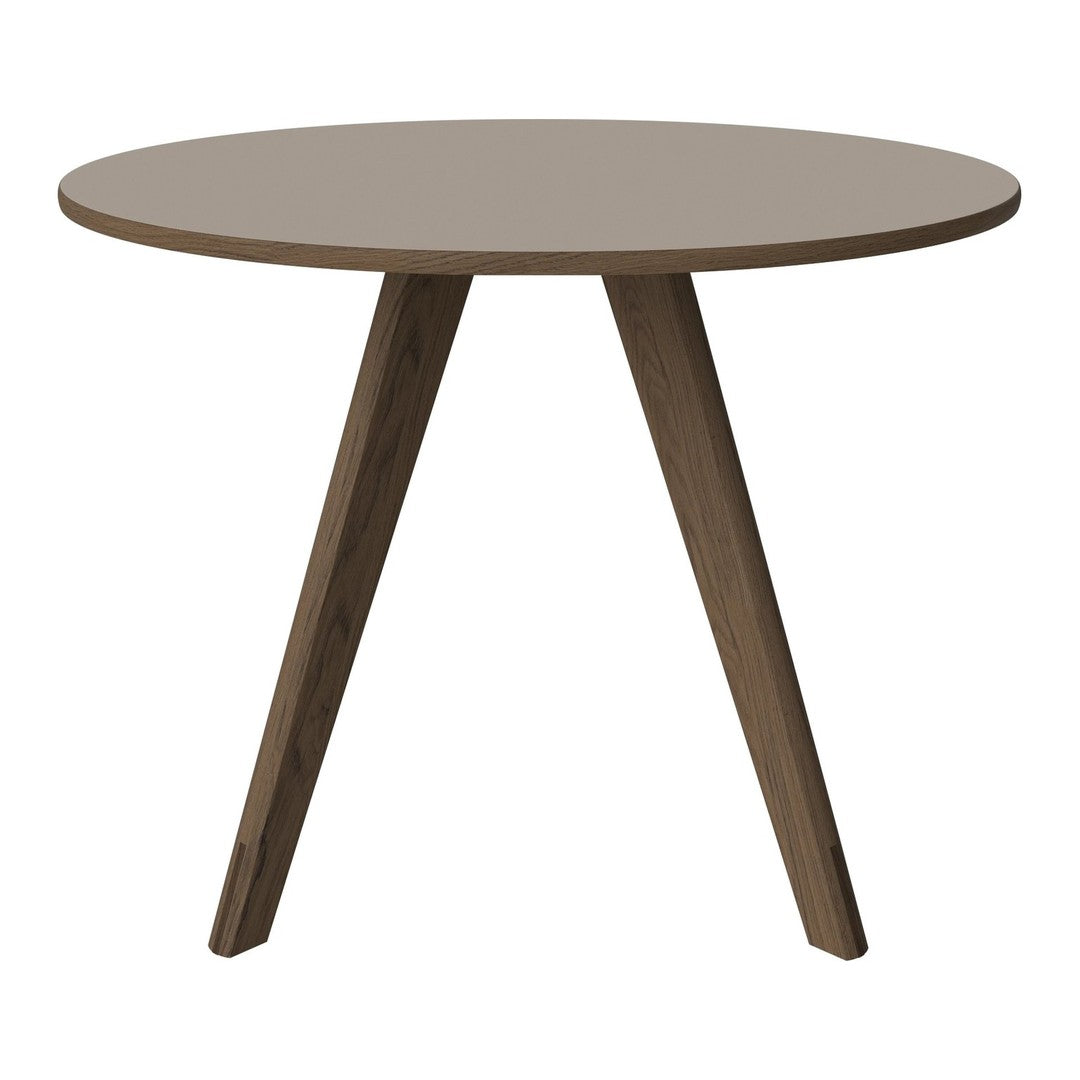 Round table with a smooth taupe top and dark wood tapered legs, ideal for modern or minimalist decor.