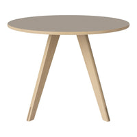 Round beige table with light wood legs, featuring a smooth, minimalist design. Perfect for modern decor.