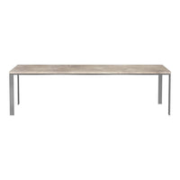 Long rectangular dining table with a light grey surface and sleek silver metal legs, minimalistic design.