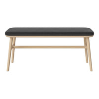 Black upholstered bench with a light wood frame, featuring clean lines and a minimalist design. Perfect for modern decor.