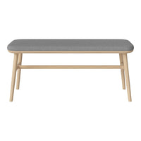 Gray upholstered bench with a smooth, minimalist design and light wood legs. Perfect for modern decor.