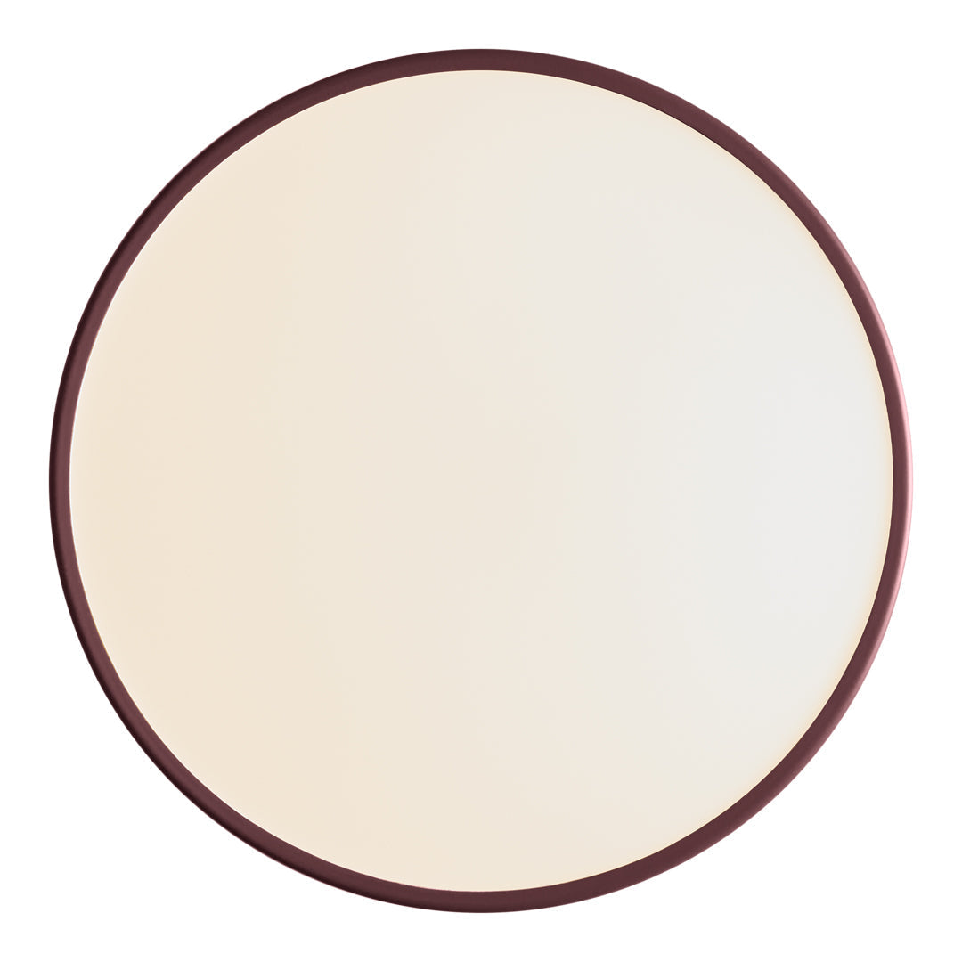 Round wall mirror with a smooth, cream surface and a deep maroon frame, offering a modern, minimalist aesthetic.