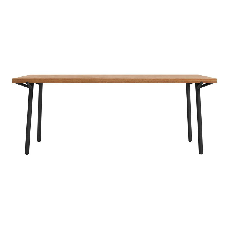 "Natural wood table with a light oak finish and sleek black metal legs, featuring a minimalist design."