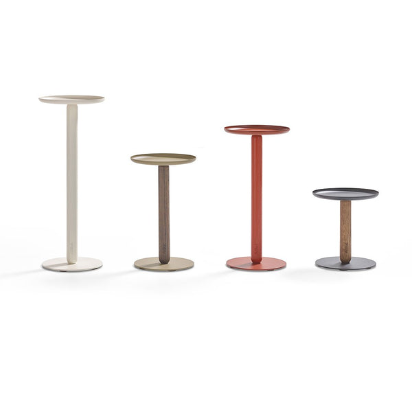 Set of four modern side tables in cream, olive green, terracotta red, and dark gray with sleek circular tops.