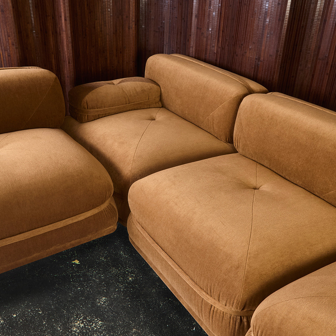 Brown velvet sectional sofa with plush, tufted cushions and clean, modern lines. Perfect for cozy living spaces.