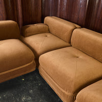 Brown velvet sectional sofa with plush, tufted cushions and clean, modern lines. Perfect for cozy living spaces.