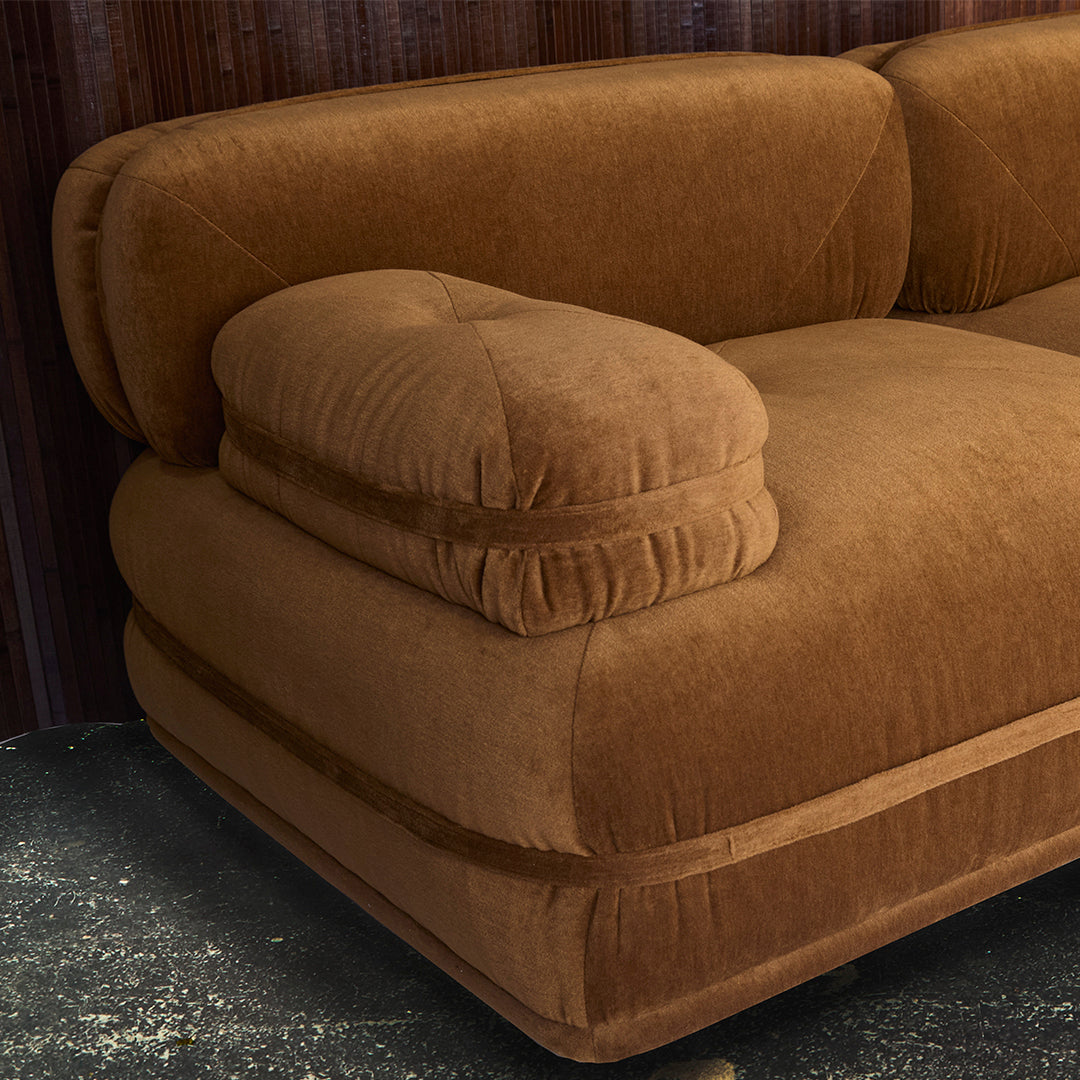 Soft brown velvet sofa with plush cushions and a smooth, modern design. Perfect for cozy living spaces.